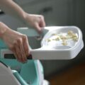 BABY EINSTEIN Podsedák na stoličku s 2 hračkami 2v1 Dine&Discover 6m+ do 23 kg